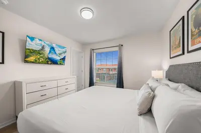 a white bedroom with a bed and a window at 8564 Bay Lilly Loop in Kissimmee