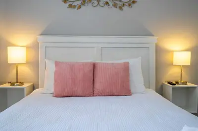 a pink pillow sitting on top of a white bed at Stylish 4BR Townhome Private Pool BBQ & Near Disney in Kissimmee