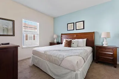 a bedroom with a bed and a desk and a window at Casa 4Q Moderna em Lucaya Village Kissimmee in Kissimmee