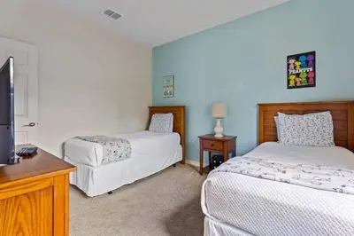 a bedroom with two beds and a flat screen tv at Casa 4Q Moderna em Lucaya Village Kissimmee in Kissimmee