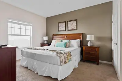 a bedroom with a large bed and a window at Casa 4Q Moderna em Lucaya Village Kissimmee in Kissimmee
