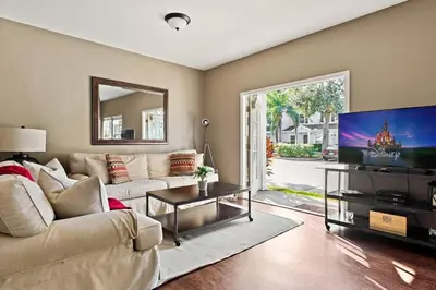 a living room with a couch and a flat screen tv at Casa 4Q Moderna em Lucaya Village Kissimmee in Kissimmee