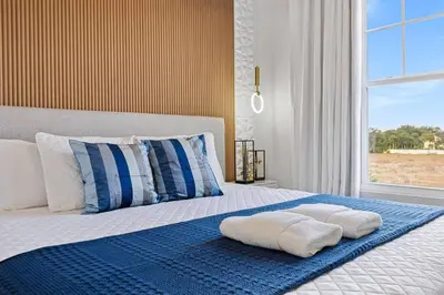 a bedroom with a bed with two towels on it at 5 Suites Sleeps 14 Lion King Mickey Theme in Orlando