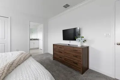 a bedroom with a bed and a television on a dresser at Casa 4Q Chic Storey Lake - Perto Disney in Kissimmee