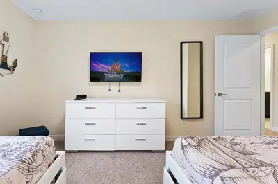 a bedroom with a white dresser and a mirror at Casa 4Q Storey Lake - Piscina Privativa in Kissimmee