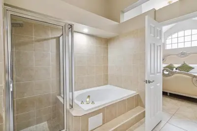 a bathroom with a tub and a walk in shower at Disney Heated Pool & Arcade Home 15 mins to Park in Kissimmee