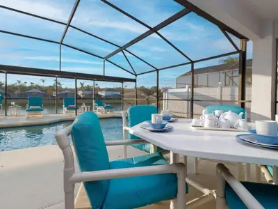 a dining table and chairs with a view of a pool at Holiday Home Villa mit 6 Schlafzimmern und atemberaubendem Seeblick by Interhome in Kissimmee