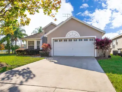 a house with a white garage at Holiday Home Moderne Villa mit Seeblick nur wenige Minuten von Disney entfernt by Interhome in Kissimmee