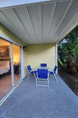 a patio with chairs and a table on a porch at Apartment 3-Bett-Eigentumswohnung Familienspaß in der Nähe von Disney by Interhome in Kissimmee