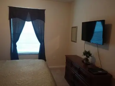 a bedroom with a bed and a tv and a window at Apartment Wasserpark Fantastischer Pool Nur wenige Minuten von Disney Parks entfernt by Interhome in Orlando