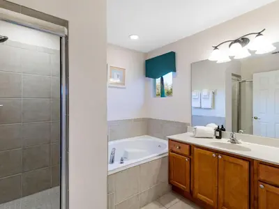 a bathroom with a tub and a sink and a shower at Holiday Home Florida Breeze mit Whirlpool by Interhome in Kissimmee