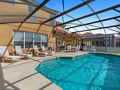 a large swimming pool with chairs and a building at Holiday Home Florida Breeze mit Whirlpool by Interhome in Kissimmee