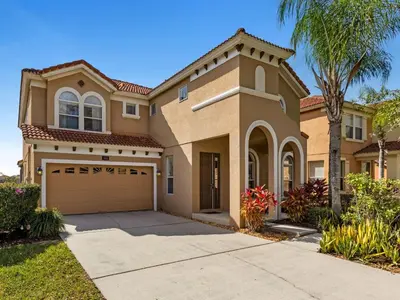 a house with a driveway and a garage at Holiday Home Florida Breeze mit Whirlpool by Interhome in Kissimmee