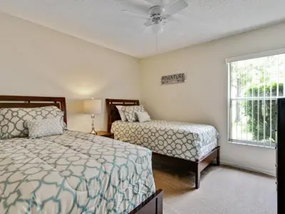 a bedroom with two beds and a window at Holiday Home Entspannende Familienvilla mit privatem Pool und Spa- Große Lanai mit reichlich by Interhome in Orlando