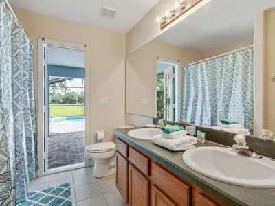 a bathroom with two sinks and a toilet and a window at Holiday Home Entspannende Familienvilla mit privatem Pool und Spa- Große Lanai mit reichlich by Interhome in Orlando