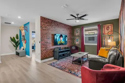 a living room with a couch and a brick wall at Disney & Universal House with Pool & Arcade in Kissimmee