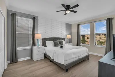 a bedroom with a bed and a ceiling fan at Disney & Universal House with Pool & Arcade in Kissimmee