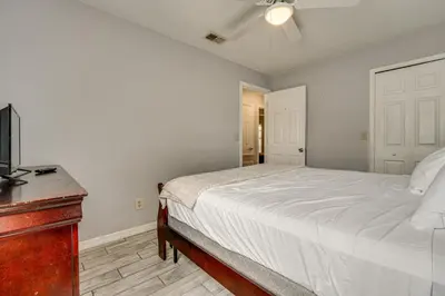 a bedroom with a bed and a tv and a dresser at Family Theme Park Hub with Pool in Kissimmee in Kissimmee
