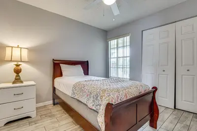 a bedroom with a bed and a dresser and a window at Family Theme Park Hub with Pool in Kissimmee in Kissimmee