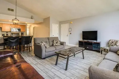 a living room with a couch and a tv and a table at Family Theme Park Hub with Pool in Kissimmee in Kissimmee