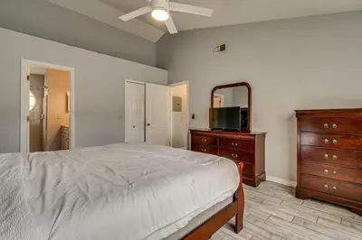 a bedroom with a bed and a dresser and a mirror at Family Theme Park Hub with Pool in Kissimmee in Kissimmee