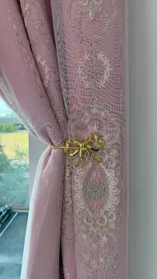 a pink curtain tied up with a bow at Disney Princess and Heroes Apartment Accessible in Orlando
