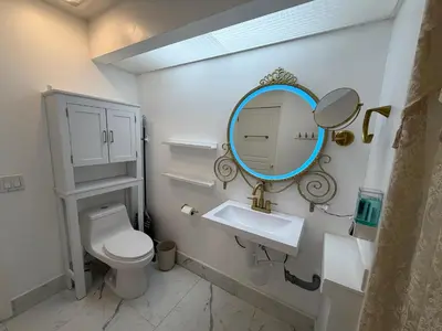 a bathroom with a white toilet and a mirror at Disney Princess and Heroes Apartment Accessible in Orlando