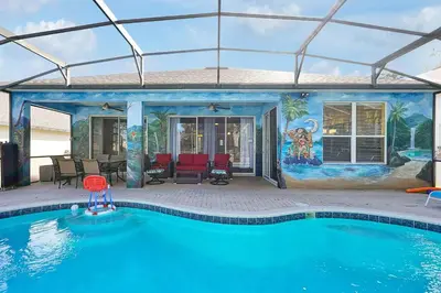 a swimming pool in front of a house with a mural at 4BR Family Villa Pool Game Room Near Disney in Orlando