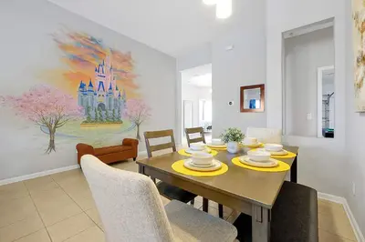 a dining room with a table with chairs and a painting at 4BR Family Villa Pool Game Room Near Disney in Orlando