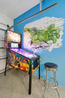 a childs room with a superhero mural and a stool at 4BR Family Villa Pool Game Room Near Disney in Orlando