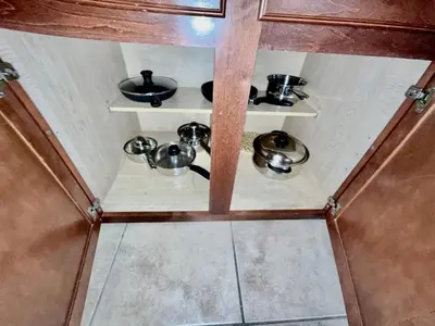 a small kitchen with pots and pans on shelves at Entire Condo 3Bed 2Bath 5 mins to Disney Park in Orlando