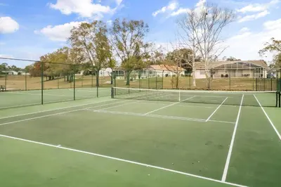 a tennis court with two tennis courts at Residentas Hali Ridge in Orlando