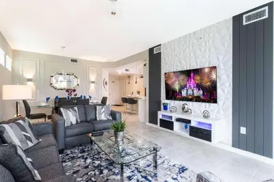 a living room with a couch and a tv on a wall at Lake view Near Disney Resort w Lazy River 108 in Kissimmee