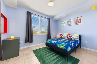 a bedroom with blue walls and a bed with a green rug at Mario & Fairy 3BR Condo w Free Water Park 303 in Kissimmee
