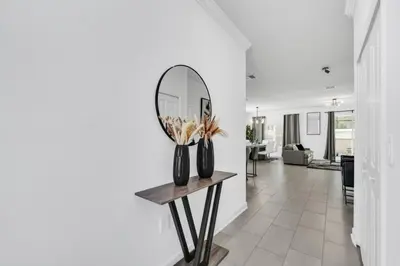 a hallway with a mirror and a table with vases at Luxury, Luxury, Luxury Pool Home! townhouse in Kissimmee