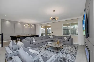 a living room with a couch and a table at 9 Bedroom With Everything For Happiness! home in Kissimmee