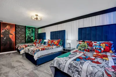two beds in a room with superheroes at 9 Bedroom With Everything For Happiness! home in Kissimmee