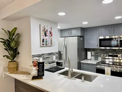 a kitchen with a refrigerator and a counter with a statue at Superior 3BR Condo Apartment Near Disney Attractions in Kissimmee