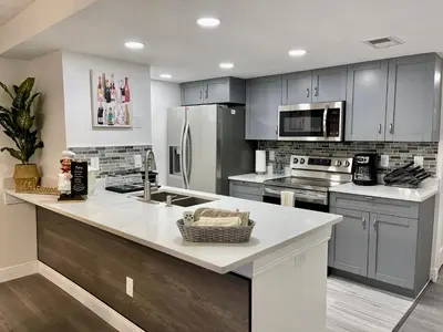 a kitchen with gray cabinets and a white counter top at Superior 3BR Condo Apartment Near Disney Attractions in Kissimmee