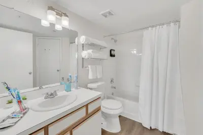 a white bathroom with a sink and a toilet at Grand Luxury 2BR Penthouse near Disney Parks in Kissimmee