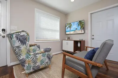 a living room with a chair and a television at Bungalow near Universal, Disney, and Downtown Orlando in Orlando