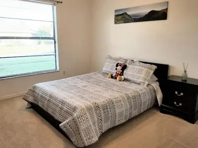 a teddy bear sitting on a bed in a bedroom at 4 Bedroom Private Pool House - 5 Mi to Convention Center & 7 Mi to Disney in Orlando