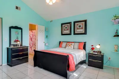 a bedroom with a bed and a blue wall at Bright Lakefront Sanford Home with Community Pool in Sanford