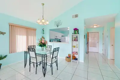 a dining room with a glass table and chairs at Bright Lakefront Sanford Home with Community Pool in Sanford