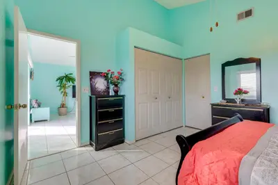 a bedroom with a red bed and a mirror at Bright Lakefront Sanford Home with Community Pool in Sanford