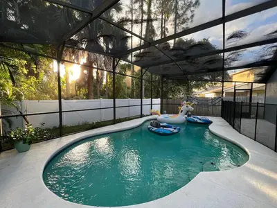 a swimming pool with a pool noodle in a house at Beautiful pool home 15 minutes from Disney! in Kissimmee
