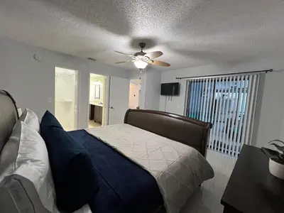 a bedroom with a bed and a ceiling fan at Beautiful pool home 15 minutes from Disney! in Kissimmee