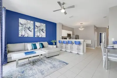 a living room with a white couch and a blue wall at Disney Min Away - Pool Patio & BBQ in Orlando