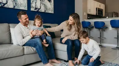 a family sitting on a couch with a baby at Disney Min Away - Pool Patio & BBQ in Orlando