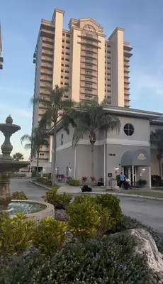 a large building with palm trees in front of it at Blue Heron Resort in Orlando